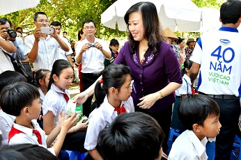 : Bà Đào Hồng Lan, Thứ trưởng Bộ Lao động Thương bình và Xã hội trao tặng sữa cho các em học sinh tại Trà Ôn, Vĩnh Long.